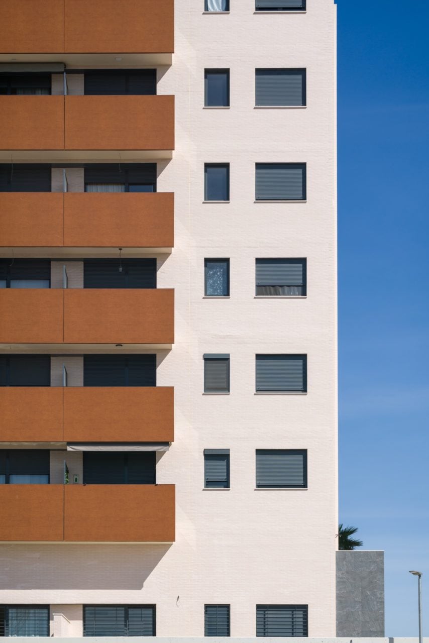 Detalle de la fachada en color claro y las terrazas con acabado fenólico